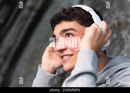 Joyeux adolescent hispanique à écouter de la musique avec un casque Banque D'Images