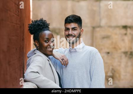 Deux amis de différentes origines se tenant souriant à l'extérieur de l'appareil photo Banque D'Images