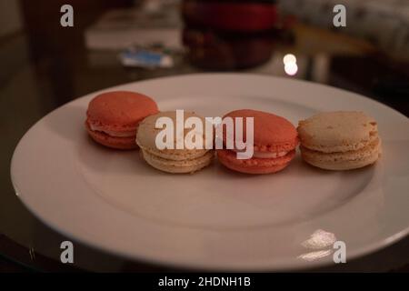 Macarons aromatisés à la noix de coco et à la rose sur l'assiette Banque D'Images