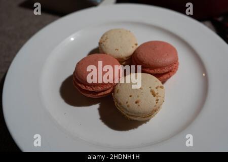 Macarons aromatisés à la noix de coco et à la rose sur l'assiette Banque D'Images