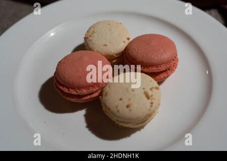 Macarons aromatisés à la noix de coco et à la rose sur l'assiette Banque D'Images