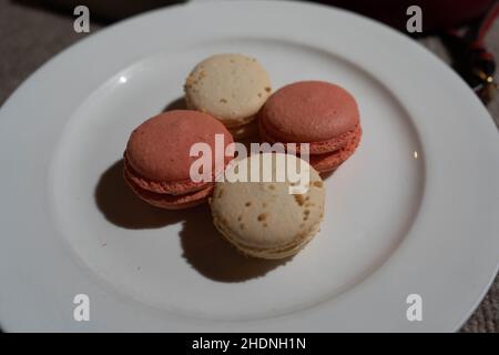 Macarons aromatisés à la noix de coco et à la rose sur l'assiette Banque D'Images