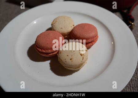 Macarons aromatisés à la noix de coco et à la rose sur l'assiette Banque D'Images