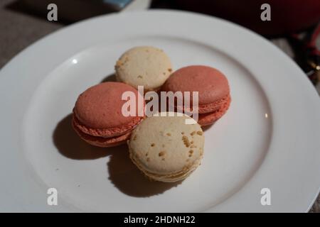 Macarons aromatisés à la noix de coco et à la rose sur l'assiette Banque D'Images