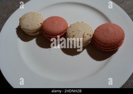 Macarons aromatisés à la noix de coco et à la rose sur l'assiette Banque D'Images