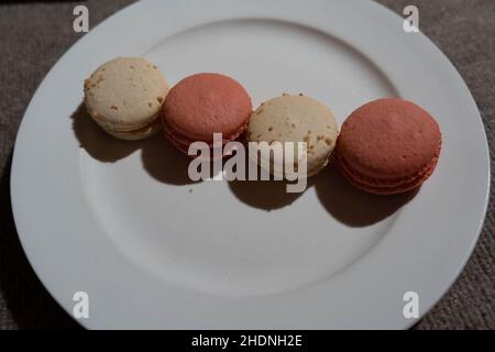 Macarons aromatisés à la noix de coco et à la rose sur l'assiette Banque D'Images