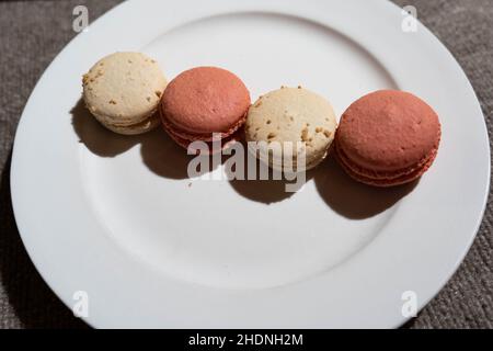 Macarons aromatisés à la noix de coco et à la rose sur l'assiette Banque D'Images