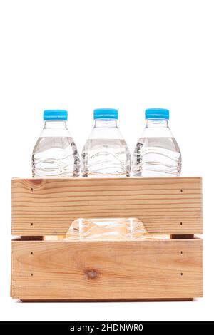 Groupe de petites bouteilles d'eau en plastique dans une caisse en bois.Isolation photo de studio. Banque D'Images