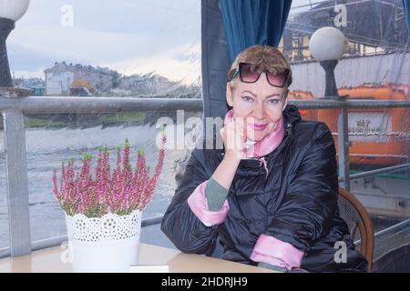 Portrait d'une femme mûre à une table dans un café sur le quai de la Vistule à Cracovie.Début novembre Banque D'Images
