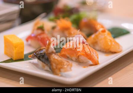 Sushi dans une assiette blanche sur la table, sélection de l'accent sur le saumon sushi, gros plan sur la mise en place de sushi.Une alimentation japonaise saine. Banque D'Images