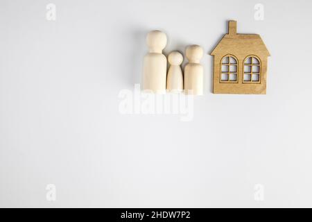 Chiffres de famille sur fond blanc près de la maison.Concept de famille et de maison heureux.Parents et enfants avec espace de copie Banque D'Images