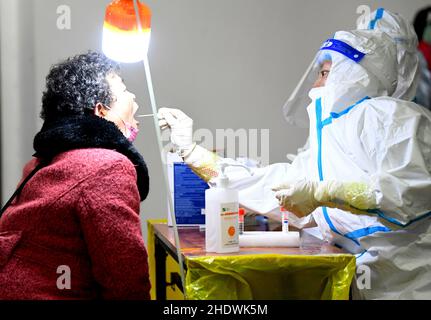 (220107) -- ZHENGZHOU, 7 janvier 2022 (Xinhua) -- Un travailleur médical prélève un échantillon par écouvillon pour les tests COVID-19 sur un site d'essai à Zhengzhou, dans la province de Henan, dans le centre de la Chine, le 7 janvier 2022.La ville de Zhengzhou, capitale de la province de Henan au centre de la Chine, a signalé 42 nouveaux cas confirmés par la COVID-19 transmis localement à 8 heures vendredi, a déclaré les autorités locales.Les cas confirmés, âgés de deux à 66 ans, sont tous dispersés dans différents quartiers de la ville.Ils ont des symptômes légers et sont dans un état stable.(Xinhua/Hao Yuan) Banque D'Images