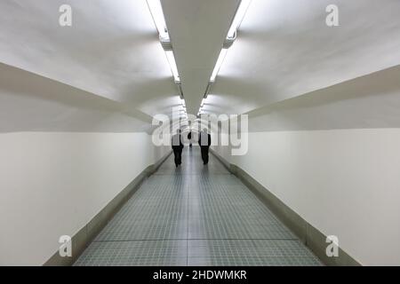 Silhouettes dans un long passage souterrain à Shanghai, en Chine Banque D'Images