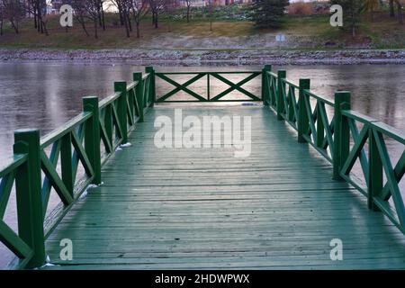 Petite jetée en bois vert dans une froide journée d'hiver au bord de la rivière Banque D'Images