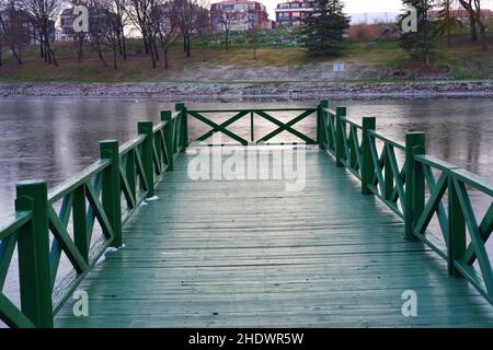 Petite jetée en bois vert dans une froide journée d'hiver au bord de la rivière Banque D'Images