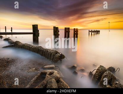 Photographie longue exposition des défenses maritimes de Bawdsey au lever du soleil sur la côte du suffolk au Royaume-Uni Banque D'Images