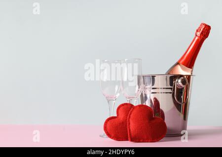 La Saint-Valentin compositon de champagne ou de vin mousseux, boîte cadeau coeur, verres à vin sur fond bleu.Carte de vœux avec espace de copie. Banque D'Images