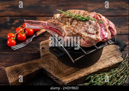 Steak grillé aux yeux de côtes de Tomahawk sur le gril avec des herbes.Arrière-plan en bois.Vue de dessus Banque D'Images