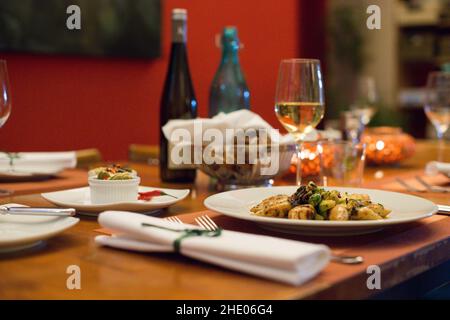 Une table de restaurant en bois est élégamment fixée et les calamars grillés sont prêts à être mangés sur une assiette. Banque D'Images