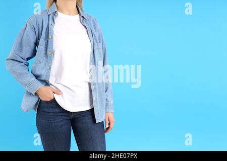 Femme en t-shirt blanc et en Jean sur fond bleu Banque D'Images