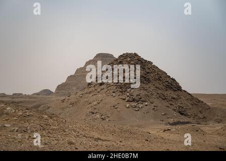 Vue vers la pyramide Userkaf avec la pyramide Step de Djoser en arrière-plan.Vestiges archéologiques dans la nécropole de Saqqara, Égypte Banque D'Images