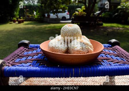 Recette Tilgul ladoo. Graines de sésame blanc enrobées de sucre de jaggery.Des sucreries indiennes servies mangées du mithai traditionnel indien jusqu'au bati Banque D'Images