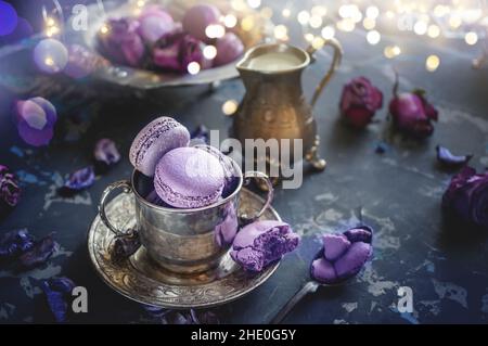 Pâtes assorties encore plus nature dans une tasse d'argent pour le thé. Composition en très peri couleur avec des reflets et des guirlandes légères. Banque D'Images