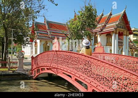 Femme Visiteur sur le magnifique pont de flexion traverser un canal à l'intérieur de Wat Benchamabophit (le Temple de marbre), Bangkok, Thaïlande Banque D'Images