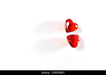 Studio mage de deux coeurs rouges étincelants de pierres précieuses sur un fond blanc de studio Banque D'Images