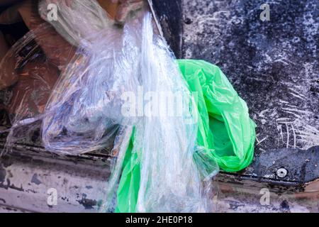 Déchets en plastique blanc et vert dans un ancien contenant blanc pour la taille en plastique.Concept de tri des déchets.Écologie et recyclage.Poubelle pleine, chutes de déchets Banque D'Images