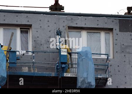 Varsovie, Pologne - 10 novembre 2021 : isolation d'un immeuble en polystyrène.Ouvriers de construction sur échafaudage.Réduction des coûts de chauffage dans Banque D'Images