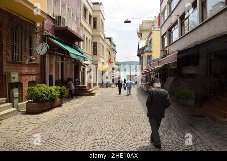 Un vieil homme marche dans la rue et il est trop tard pour voir l'horloge à Istanbul. Banque D'Images