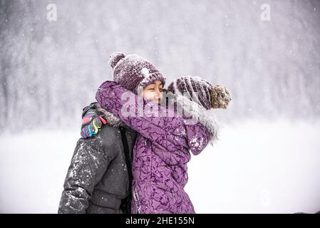Lake Louise, Canada - 23 2021 décembre : mère et fille embrassant joyeusement le lac Louise Banque D'Images