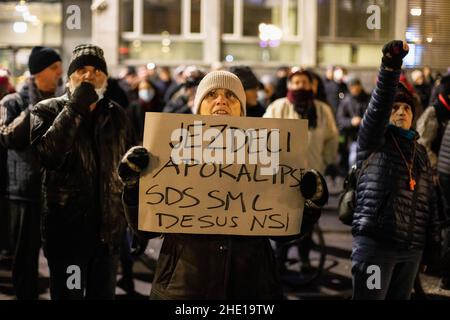 Un manifestant dans une foule tient un panneau appelant les quatre partis du gouvernement à se venger de l'apocalypse lors d'une manifestation anti-gouvernementale devant le siège de la télévision nationale slovène.pour le vendredi 90th consécutif,Les habitants de Ljubljana ont protesté contre le gouvernement du Premier ministre Janez Jansa et contre son prétendu démantèlement de la démocratie dans le pays.La dernière manifestation s'est adressée à la direction de la télévision nationale refusant de renouveler les contrats à tout un ensemble de chroniqueurs pour un programme TV critique Studio City, tout en appelant à une audition pour un num Banque D'Images