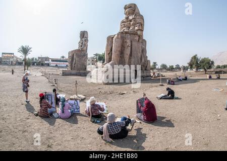 Sur le site historique Colossi of Memnon, un groupe d'étudiants d'art égyptiens s'assoient et dessinent les anciennes statues dans leurs blocs de croquis. Banque D'Images
