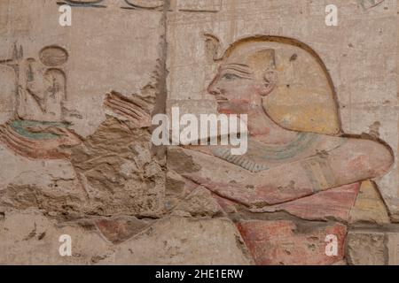 Une sculpture de relief peinte remarquablement bien conservée d'un pharaon sur un mur du temple de Karnak, un site archéologique en Égypte. Banque D'Images