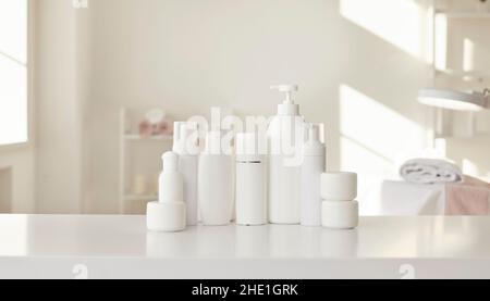 Biberons et bocaux blancs avec produits de soin de la peau professionnels dans le salon de beauté Banque D'Images