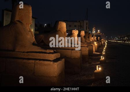 L'avenue des sphinx ou route des béliers (El Kebash), un monument historique bordé de statues à Louxor, en Égypte, après la nuit illuminée par des lumières. Banque D'Images