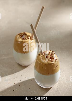 Deux verres de café Dalgona sur fond beige de table de cuisine Banque D'Images
