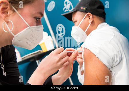 Hambourg, Allemagne.08th janvier 2022.Un membre de l'équipage du bateau de croisière Aida 'Aida Prima' est vacciné avec le vaccin Moderna lors d'une campagne de vaccination au Cruise Centre Steinwerder.Credit: Daniel Bockwoldt/dpa/Alay Live News Banque D'Images