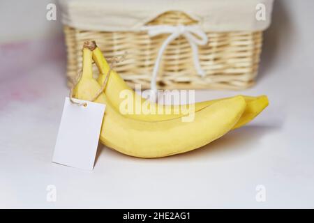 Maquette d'étiquette sur les bananes.Autocollant du produit pour le texte ou le prix.Panier en osier sur fond.Produits agricoles biologiques du marché local.Copier l'espace Banque D'Images