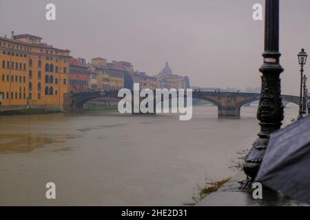 Ponts au-dessus de la rivière Arno à Florence, en Italie, à travers des bâtiments colorés sous la pluie Banque D'Images