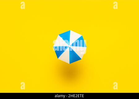 Concept de plage minimal avec parasol sur fond jaune.Fond d'été plat. Banque D'Images