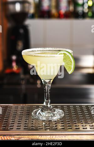 Cocktail de margarita au citron vert classique avec tequila, jus de lime, glace pilée et un peu de sel sur le bord du verre, garni d'une tranche de lime. Banque D'Images