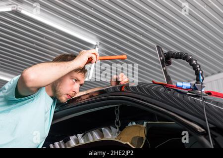 Enlever les bosses sur la carrosserie d'une voiture sans peindre.PDR. Banque D'Images