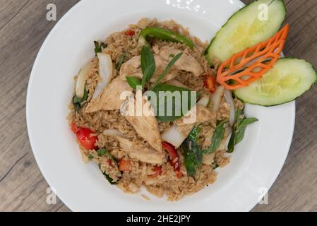 Vue en hauteur d'une généreuse portion de riz frit épicé avec des tranches de poulet pour une délicieuse pile de nourriture thaï à manger. Banque D'Images