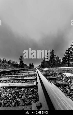 Plan à faible angle des chemins de fer abandonnés en échelle de gris Banque D'Images