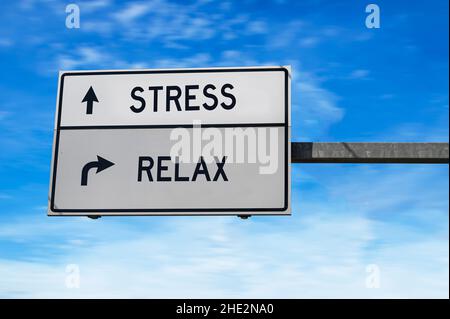 Signalisation routière avec des mots stress et relax.Deux panneaux de signalisation blancs avec flèche sur poteau métallique sur fond bleu ciel. Banque D'Images