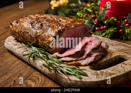 Viande rôtie en tranches, isolée sur fond de bois. Banque D'Images