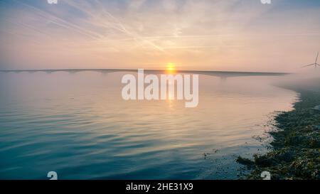 Long pont sur l'eau douce et vivivivivivivivile allant à l'infini au-dessus de l'océan magnifique sous le magnifique ciel coloré de Zeeland, aux pays-Bas Banque D'Images